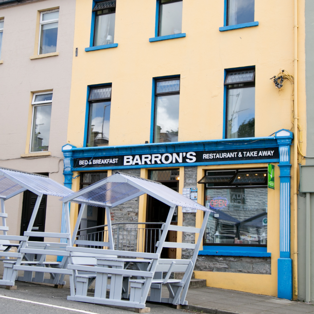 Barron's Bed and Breakfast restaurant and takeaway, yellow frontage with blue trim and covered outdoor benches