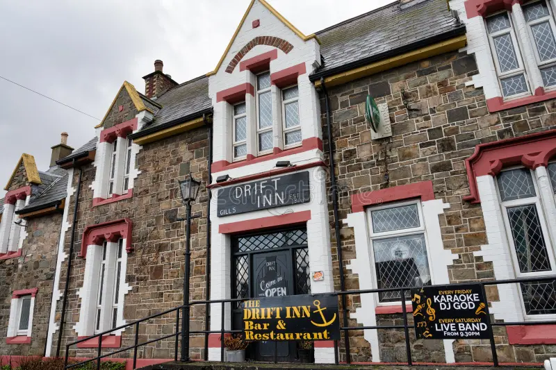 The Drift Inn pub and restaurant in a stone building with red trim, signs for karaoke and live band nights.